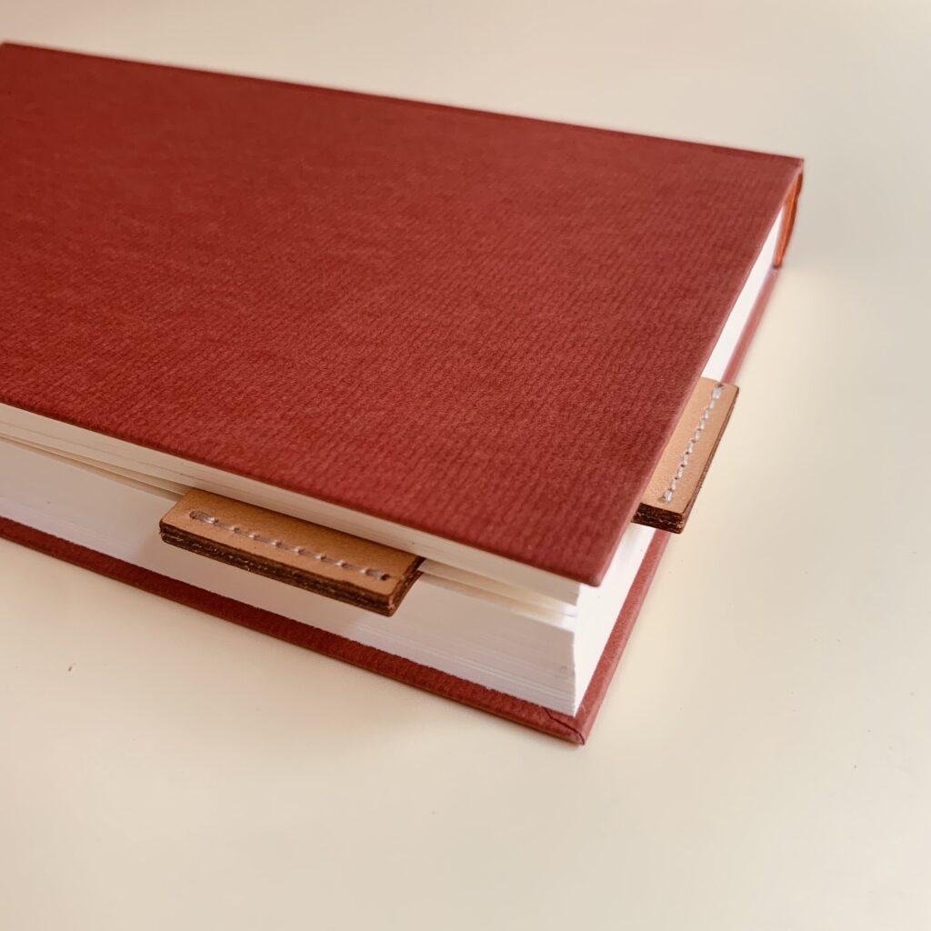 Ein rotes Buch mit einem Lesezeichen darin.